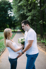 Happy pregnant woman and her husband in the park