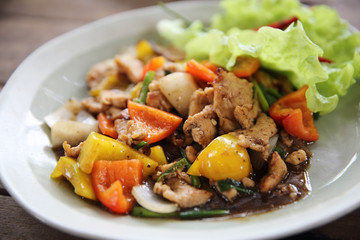Stir fry chicken with black pepper on wood background