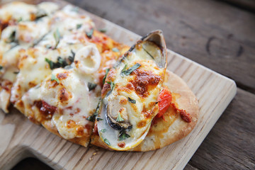 Pizza with seafood on wood background italian food