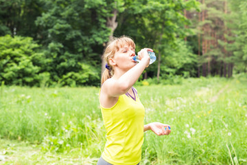 Beautiful fitness athlete woman drinking water after work out exercising outdoor portrait