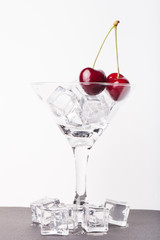 Cherry berries in a martini glass on white background