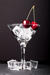 Cherry berries in a martini glass on black background