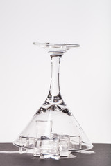 Ice cubes and martini glass on white background