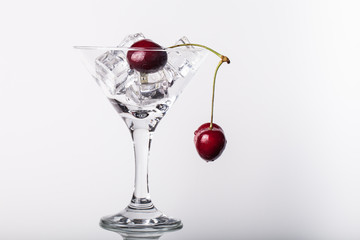 Cherry berries in a martini glass on white background