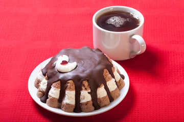 Homemade cake with bird decor on red tablecloth for background.