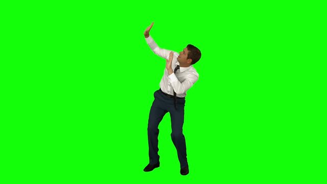 Businessman standing with arms raised on green screen background