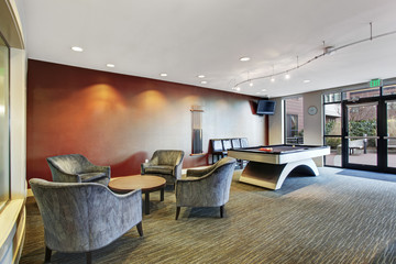 Basement room interior with comfortable chairs and biliards