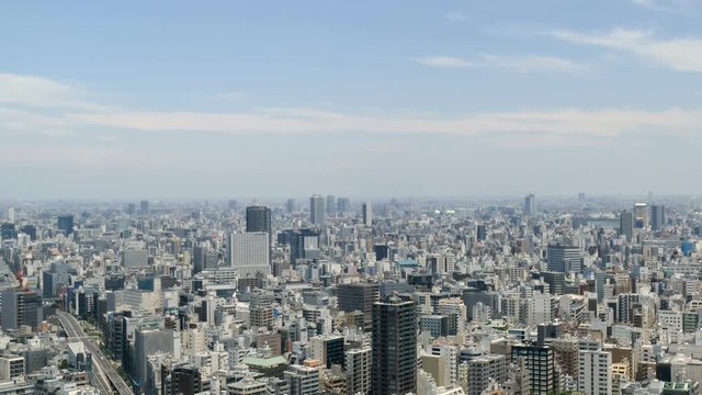 Elevated timelapse of Tokyo skyline in summer skies.