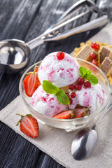 Ice Cream with Strawberry, Mint and waffles. On the wooden table.