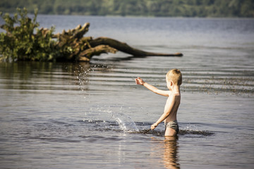 Boy playing in the water in summer