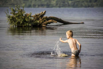 Boy playing in the water in summer