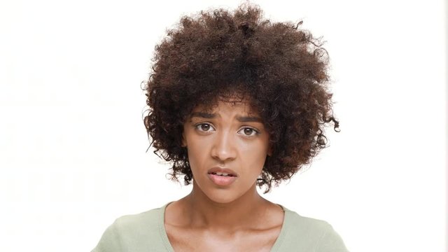 Displeased young beautiful african girl over white background.