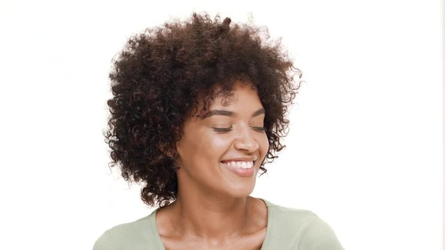 Shy young beautiful african girl laughing over white background.