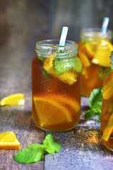 Orange iced tea in a glass jar with paper straws.