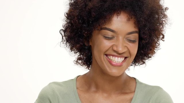 Young beautiful african girl laughing over white background. Slow motion.