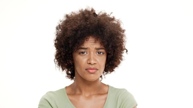 Displeased young beautiful african girl over white background. Slow motion.