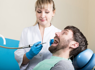Doctor examines the oral cavity on tooth decay. Caries protection. Tooth decay treatment. Dentist...