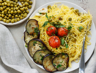 Spaghetti with green peas and fried tomatoes and eggplant