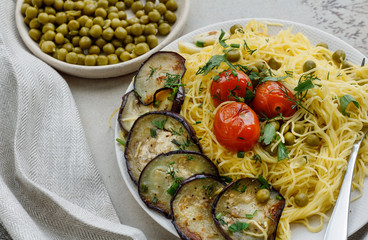 Spaghetti with green peas and fried tomatoes and eggplant