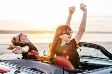 young happy couple in cabriolet in sunset light
