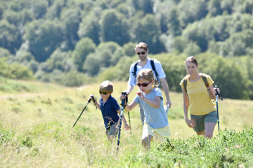 Fototapeta premium Hiking family walking together in mountain path