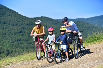Fototapeta premium Family on a biking day, parents pointing at scenery