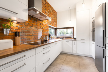 Modern designed kitchen with brick - 115631094