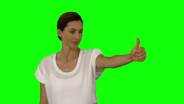 Happy businesswoman showing thumbs up on green screen background