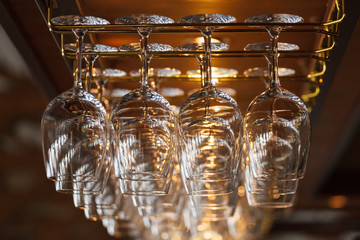 different glasses hanging over the bar. Soft focus.