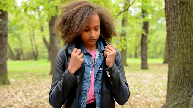 young punctual tidy charming african girl adjust her look in the forest - she modify her clothes 