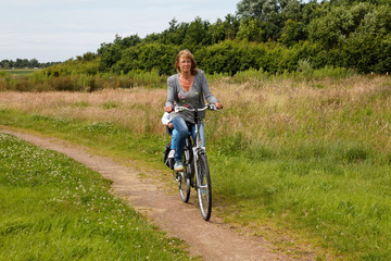 Fototapeta premium woman with child cycling in nature on a bike path