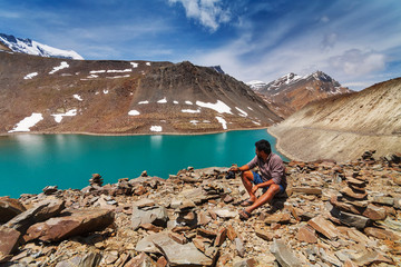 Photographer is sitting near Suraj Taal Lake in Himalaya - obrazy, fototapety, plakaty
