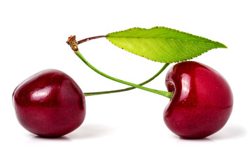 Two cherries with leaf closeup isolated on white background