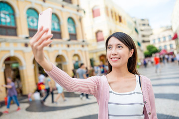 Woman taking selfie in Senado Square of Macao city