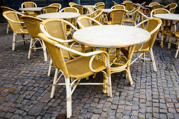 Fototapeta na wymiar Street view of a coffee terrace with tables and chairs in europe