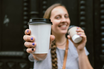 Young woman drinking coffee from disposable cup