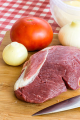 Slice of raw pork meat on the cutting board