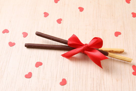Pair of chocolate dipped biscuit sticks tied to ribbon