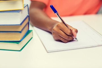 close up of african woman hand writing to notebook