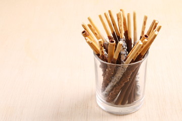 Assorted chocolate dipped biscuits sticks in glass holder