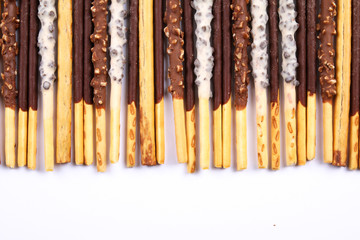 Assorted chocolate dipped biscuit sticks on white background