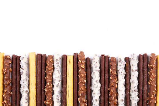 Assorted chocolate dipped biscuit sticks on white background