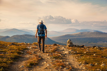 hiker with backpack traveling in Norway mountains Dovre