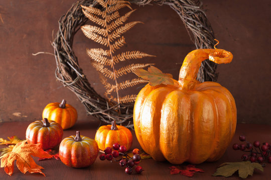 decorative golden papier-mache pumpkin and autumn leaves for hal