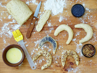 Preparation of bagels dough, greased egg and sprinkle with poppy seeds and flax seeds on a wooden...