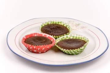 Three homemade chocolate muffins on the plate isolated over whit