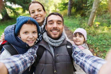 family with backpacks taking selfie and hiking - Powered by Adobe