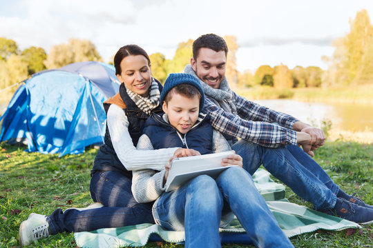 happy family with tablet pc and tent at camp site