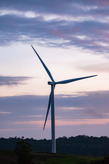 Wind turbine generator silhouette with twilight sky background. 