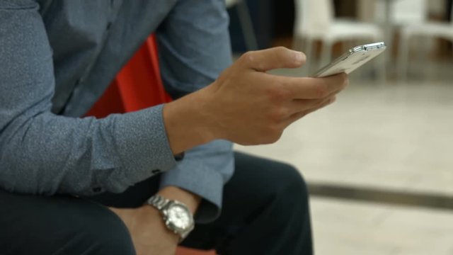 Handsome man using his smartphone in shopping mall 